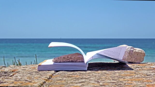 Open book with rock on beach by ocean