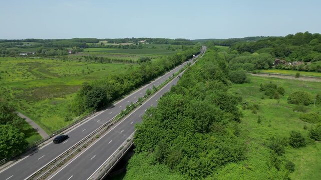 Aerial Drone View of A2 Motorway Through Lush Green Fields and Woodland Hambrook Kent UK