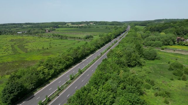 Aerial Drone View of A2 Motorway Through Lush Green Fields and Woodland Hambrook Kent UK