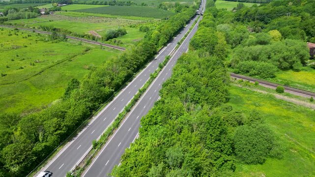 Aerial Drone View of A2 Motorway and Parallel Railway Lines Through Lush Green Countryside Hambrook Kent UK