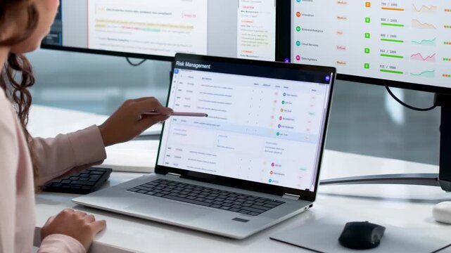 Risk Manager Carefully Analyzes Financial Data On Laptop