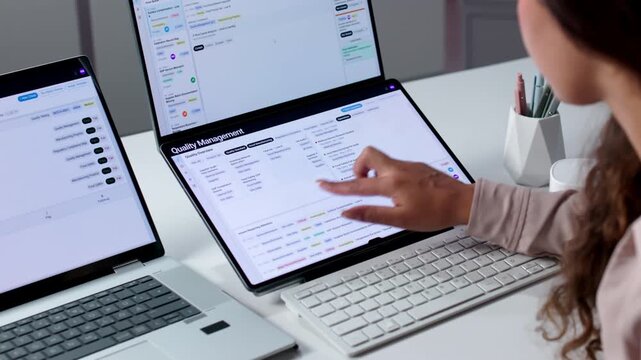 Quality Manager Reviews Corrective Action Reports On Laptop