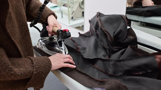Close up of hands working with textile samples or fabric swatches on a design table, showing attention to detail in material selection and fabric composition