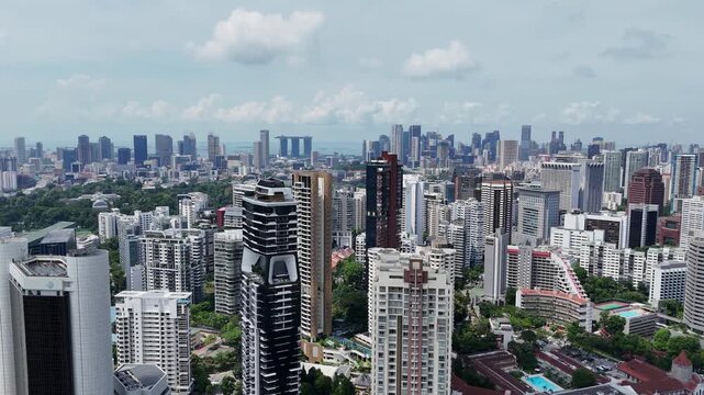 Aerial view of Singapore residential and commercial high-rise buildings, urban housing density with distant Marina Bay skyline, city planning