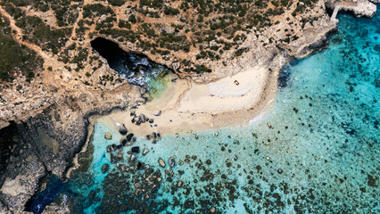 Landscape aerial drone shot Birds Eye view over the blue lagoon coast, malta with clear blue turquoise Mediterranean Sea water and limestone cliffs and green foliage in summer © STJMEDIA