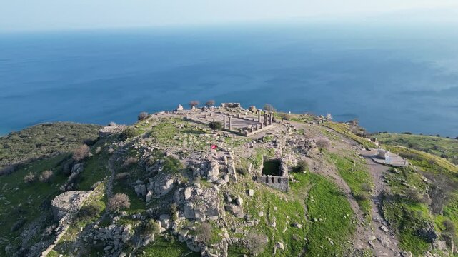 Aerial view of the ancient Temple of Athena ruins on the acropolis of Assos (Behramkale) over the Aegean Sea in Canakkale, Turkey. 4K resolution stock footage. High quality 4k footage
