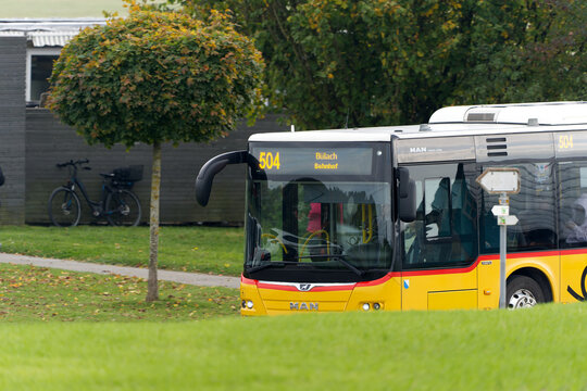 Yellow Swiss Post bus number 504 destination B&uuml;lach Bahnhof passing at Swiss village of Oberglatt on an autumn day. Photo taken October 17th, 2025, Zurich Oberglatt, Switzerland.