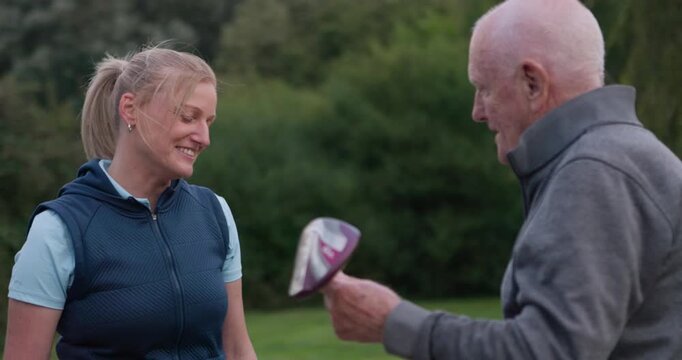 People, golf and discussion on sports, smile and equipment or driver, course and club for match. Senior man, woman and lesson or advice, conversation and support in hobby, training for technique