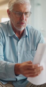 Stress, paperwork and old man in home with worry, confused or reading letter of debt. Insurance, mistake and senior person thinking with pension documents, bankruptcy notice or retirement plan