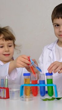 Laboratory examination of a child with test tubes, reagents and a microscope. Selective focus.