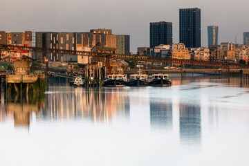 Fototapeta premium Reflections on the flat morning water of the River Thames, London