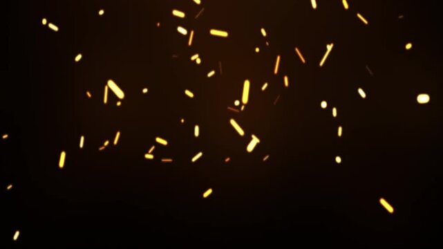 Hot fiery sparks rising from a bonfire at night floating against a black background.