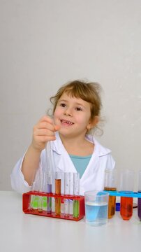 Laboratory examination of a child with test tubes, reagents and a microscope. Selective focus.
