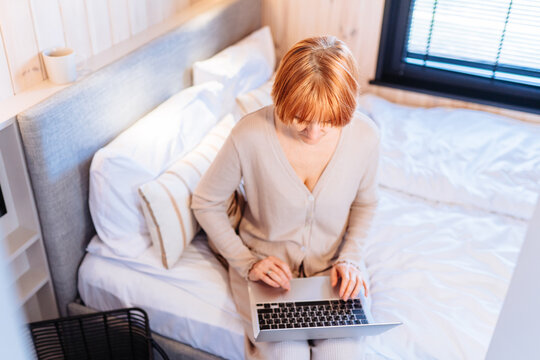 Mature Woman Working Remotely During Working vacation In Cozy Loft Cabin