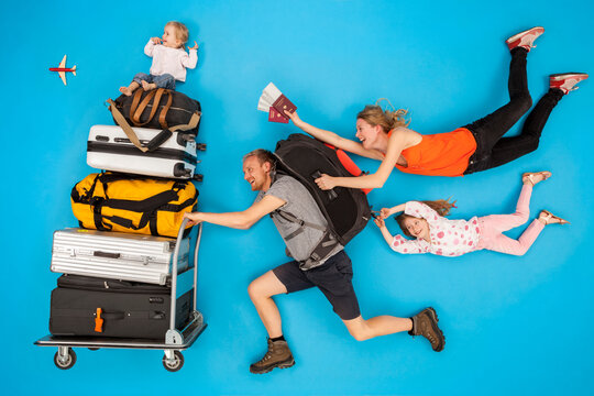 Family with luggage trolley hurrying for departure