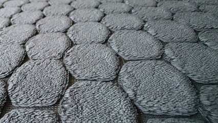 Close up of grey plush carpet with raised soft pebbles pattern, concept of cozy home interior texture © Олег