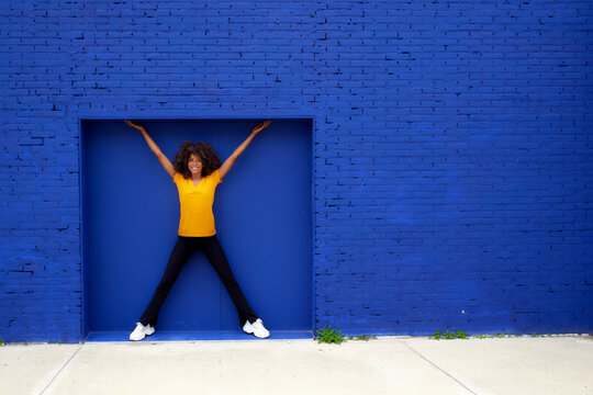 Smiling woman standing in front of blue brick wall