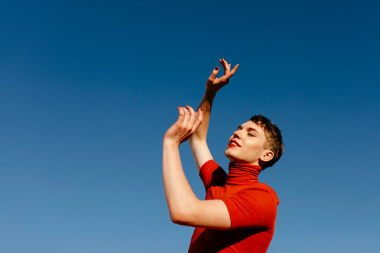 Gender fluid man dancing against clear sky on sunny day