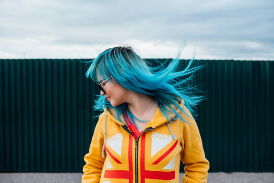 Young woman with blowing dyed blue hair