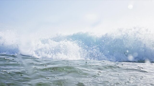 Dynamic water level shot in Tarifa, Spain capturing breaking waves, rolling barrels, white water and crystal clear turquoise Atlantic water with immersive ocean perspective.