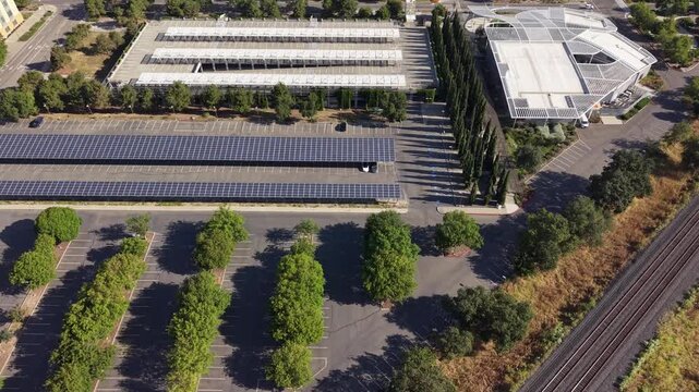 High-angle drone view over UC Davis campus showing modern buildings and expansive solar panel arrays covering parking lots, highlighting sustainable energy and campus innovation
