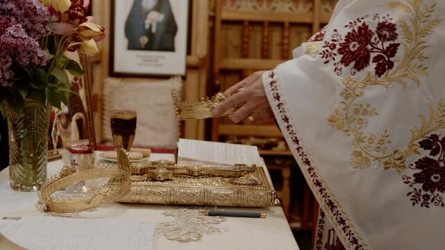 Cinematic close-up footage of an Orthodox priest performing a traditional religious ritual inside an Eastern Orthodox church. The scene features ornate liturgical garments an golden religious objects.