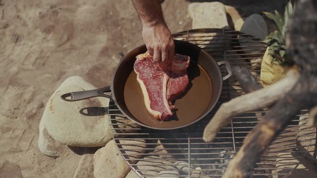 Cooking a raw T-bone steak in a cast iron pan