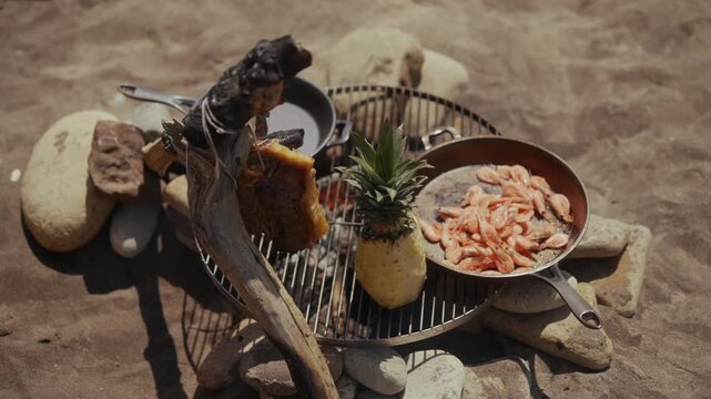 Beachside cooking with seafood, pineapple, and driftwood over fire