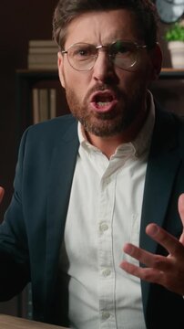 Mad furious Caucasian 40s business man working with laptop yelling looking at camera yell with anger talking rude annoyed middle-aged businessman male talk screaming work computer scream in office