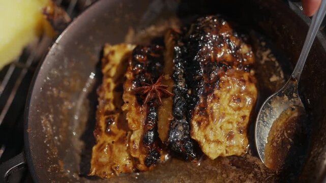 Cooking glazed meat with star anise in a cast iron pan