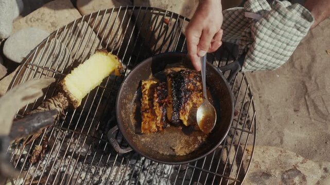 Cooking pineapple and cake on a campfire grill
