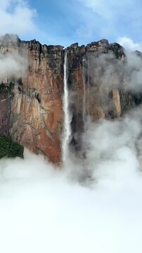 Stunning aerial video of angel falls with clouds, capturing powerful waterfall amidst misty atmosphere.