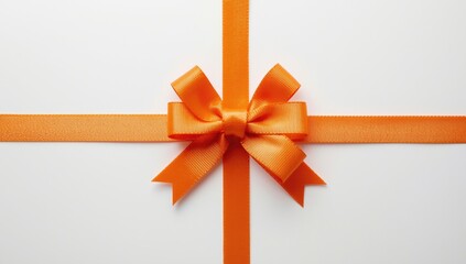 Fototapeta premium Decorative orange ribbon tied in bow on smooth white background