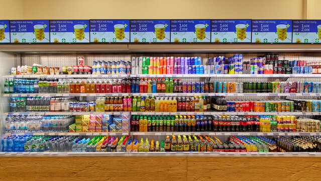 Shelves filled with various colorful soft drinks and beverages in a modern supermarket.