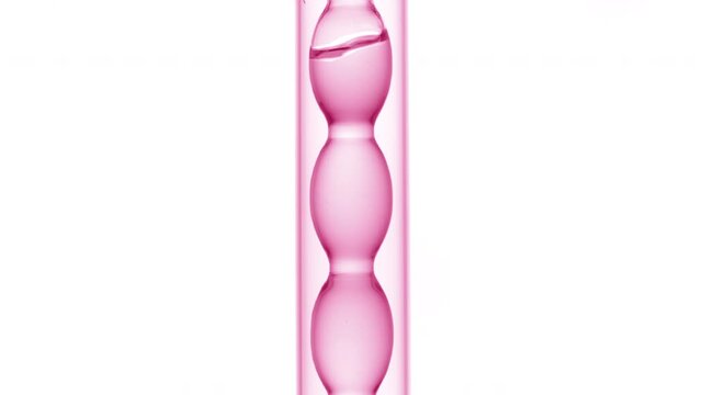 Tight close shot of air bubbles traveling through clear pink liquid as it fills and drains from a bulb lab condenser on a plain white surface | Dragon fruit liquid extract cosmetic substance concept