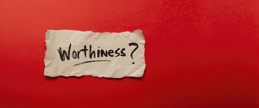 Handwritten question about worthiness on folded paper against bold red background