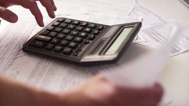 Accountant Hands Using Desktop Calculator and Checking Invoices