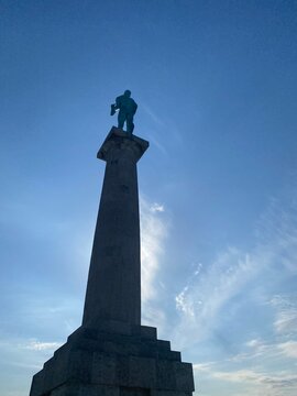 Belgrade, Serbia &ndash; April 27 2026: Victor (Pobednik) monument silhoette on stone column against bright blue sky at Belgrade Fortress