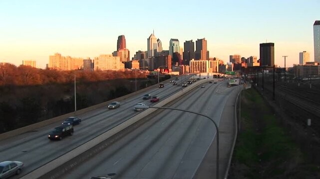 Philadelphia skyline view during sunset with heavy highway traffic on interstate 76 expressway.