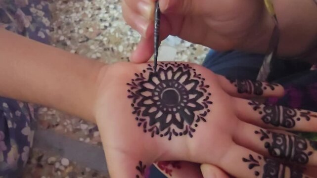 Traditional henna tattoo application on palm, intricate mandala mehndi design being painted, ethnic body art process for wedding and festival