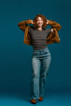 Stylish young woman showcases modern fashion in vibrant studio setting
