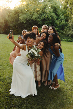 Bride taking a fun selfie with bridesmaids on a sunny wedding day