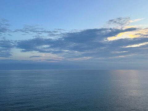 Open sea blue calm water and cloudy sky at evening.