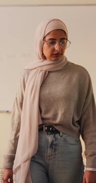 Woman, teacher and walk for supervision in class for education, invigilator and maintain discipline. Muslim, educator and observation to prevent cheating, academic assessment and monitoring behavior