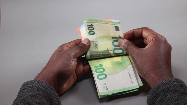 Hands Counting a Stack of 100 Euro Banknotes, Symbolizing Diaspora Remittance Flows, Immigrant Earnings, Personal Financial Success, and Foreign Currency Exchange