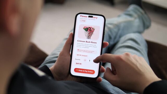 Hands holding a phone with a flower delivery app open. The screen highlights Delivered with care to your special someone and a red button. Great for showcasing romance, gift-giving, and digital retail