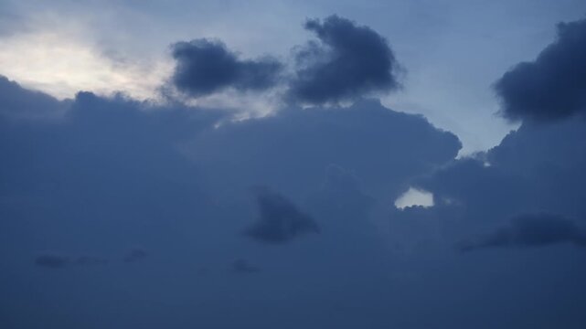 Dark clouds gather across the sky as sunlight filters through from behind, signaling changing weather conditions and the possibility of rain soon.