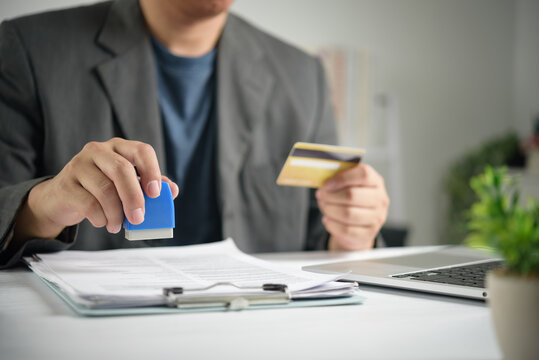 Corporate executive lifestyle showing business person using rubber stamp authorizing legal contract paperwork processing credit card payment and evaluating official company financial purchase