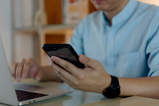 Businessman hands holding cellphone browsing internet office desk. Remote connection multitasking corporate communication workflow management smart watch.
