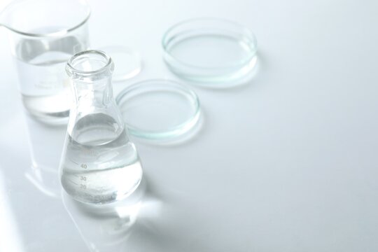 Chemical laboratory equipment. Glassware with clear liquid. Space for text